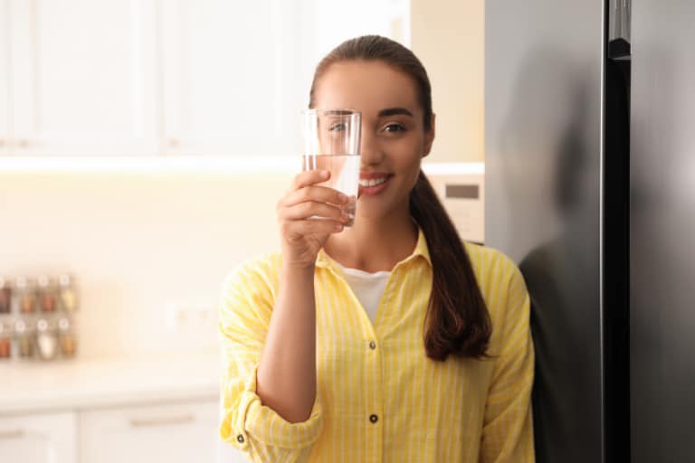 woman holding up glass of water